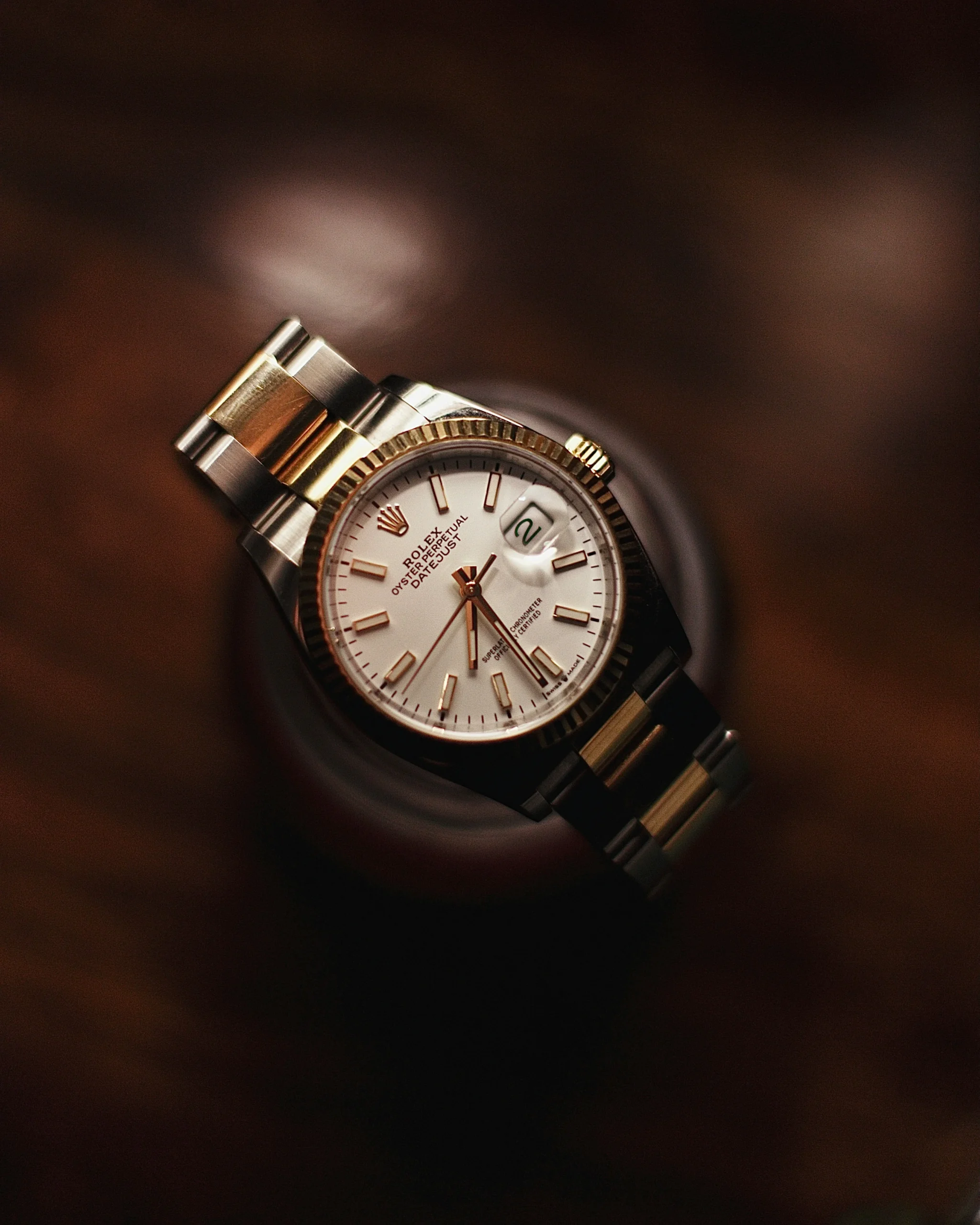 Rolex Price Chart 2026 collection display showing Submariner, Daytona and GMT-Master II models on dark surface